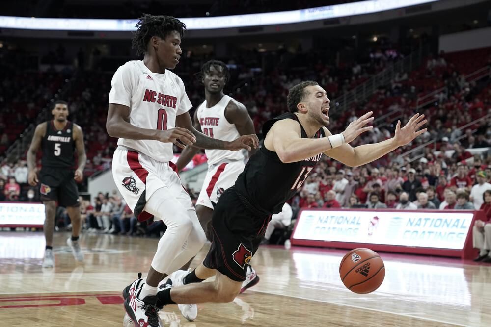 Louisville guard Jarrod West gets tripped by North Carolina State guard.jpeg